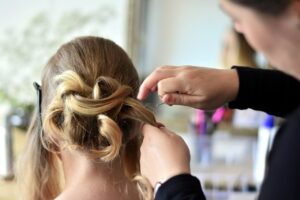 coiffeuse en salon réalisant une coiffure élégante